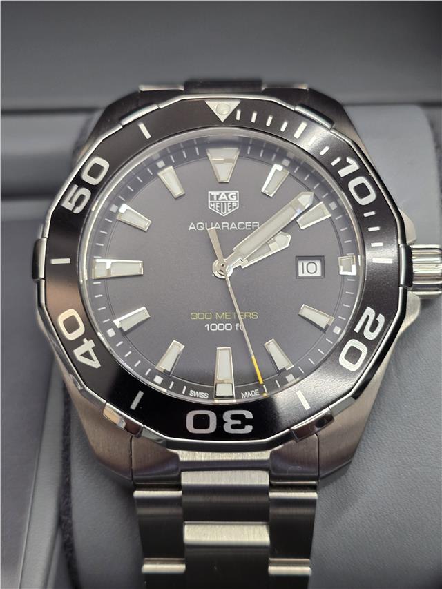 TAG Heuer Aquaracer 300 meters watch with black dial, stainless steel bracelet, and unidirectional bezel.