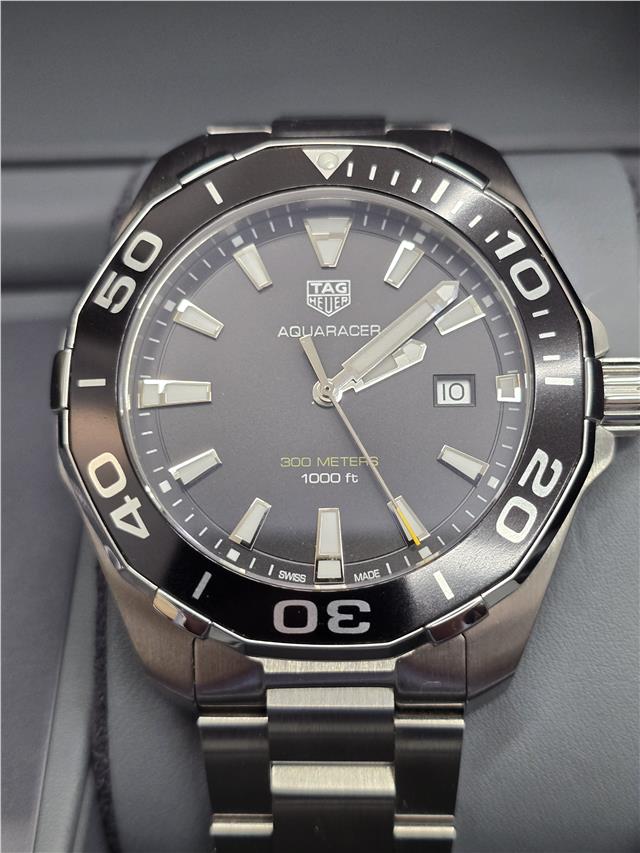 TAG Heuer Aquaracer 300 meters watch with black dial, stainless steel bracelet, and rotating bezel for diving and sports.