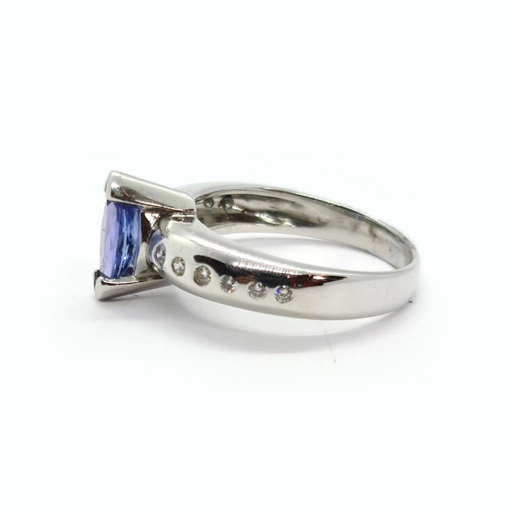 14-carat tanzanite and diamond ring with a gold band, featuring a central oval tanzanite gemstone surrounded by small diamonds.
