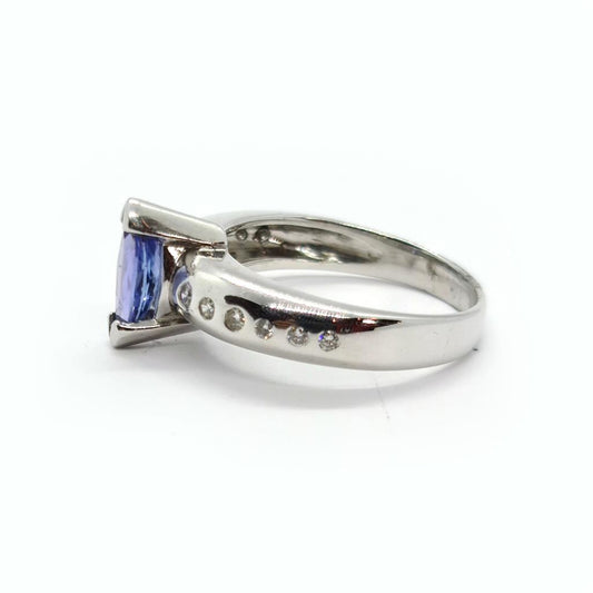 14-carat tanzanite and diamond ring with a gold band, featuring a central oval tanzanite gemstone surrounded by small diamonds.
