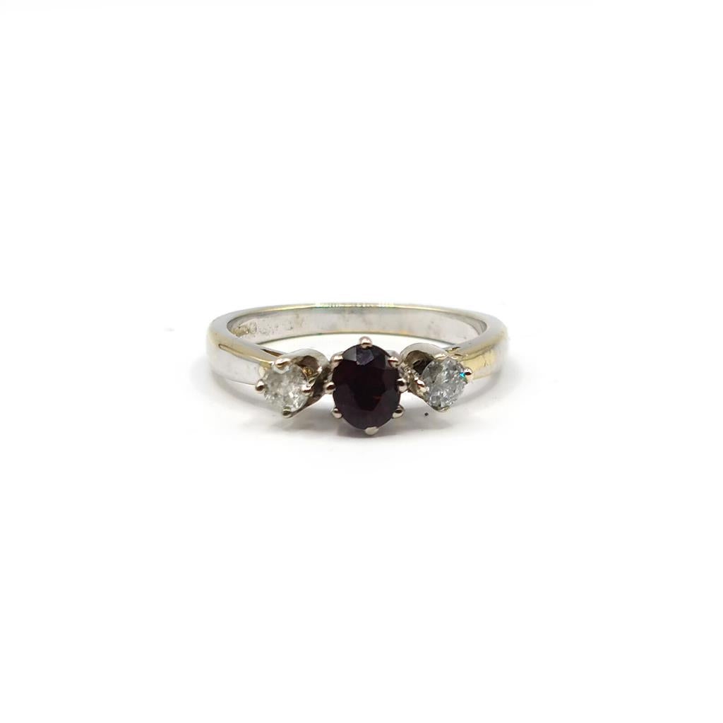 18ct white gold ring featuring 0.24 carat diamond and 0.45 carat garnet gemstone with a sleek band design.