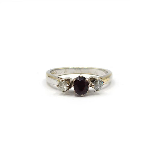18ct white gold ring featuring 0.24 carat diamond and 0.45 carat garnet gemstone with a sleek band design.