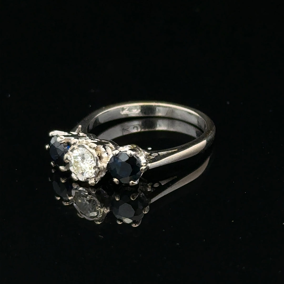 18ct white gold sapphire and diamond ring showcasing a central blue sapphire surrounded by sparkling diamonds.