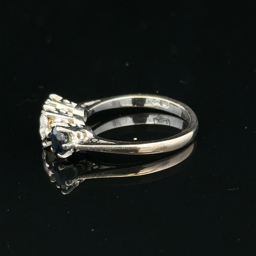 18ct white gold sapphire and diamond ring with a central blue sapphire and sparkling diamonds, elegant jewelry piece.