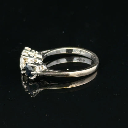 18ct white gold sapphire and diamond ring with a central blue sapphire and sparkling diamonds, elegant jewelry piece.