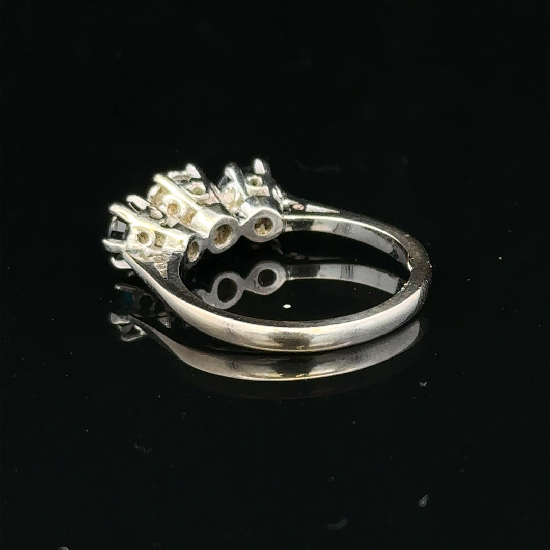 18ct white gold sapphire and diamond ring featuring a central blue sapphire surrounded by sparkling diamonds.
