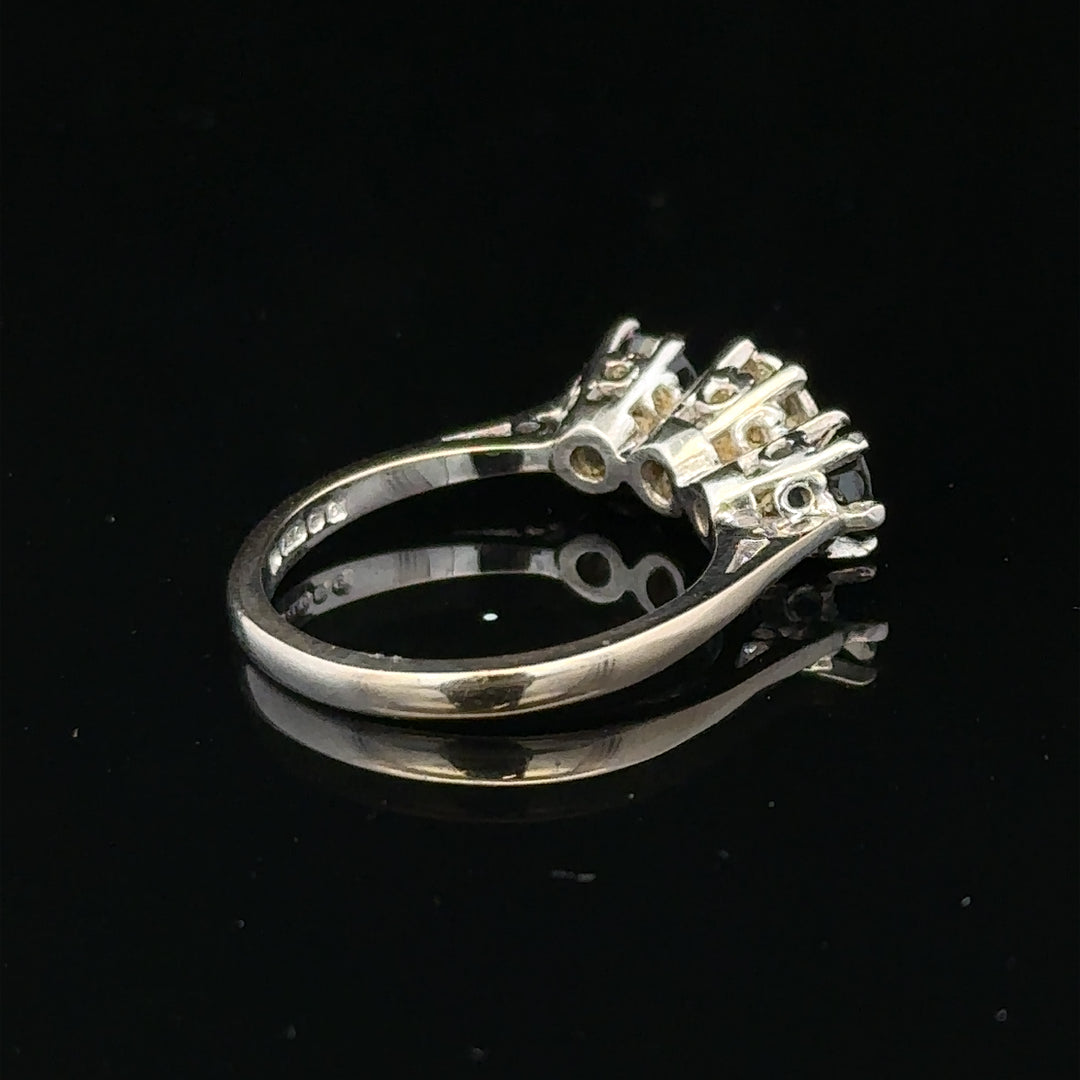 18ct white gold sapphire and diamond ring featuring a central sapphire gemstone surrounded by sparkling diamonds.