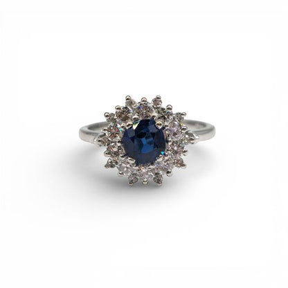18ct white gold sapphire and diamond ring with a central blue sapphire and sparkling diamonds, elegant jewelry design.