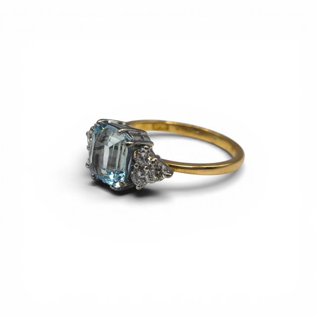 18ct yellow gold aquamarine and diamond ring featuring a large central aquamarine gemstone and sparkling diamond accents.