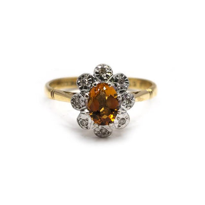 18ct yellow gold citrine and diamond ring with a central yellow gemstone and sparkling diamonds, elegant jewelry piece.