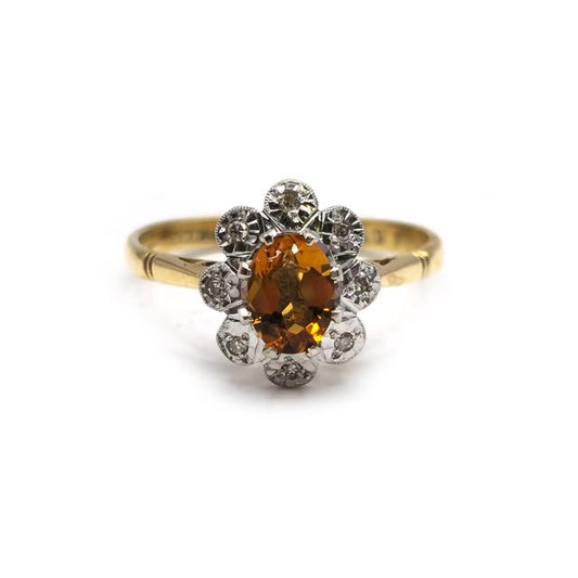 18ct yellow gold citrine and diamond ring with a central yellow gemstone and sparkling diamonds, elegant jewelry piece.