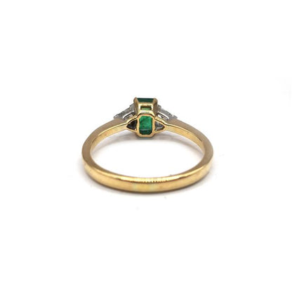 18ct yellow gold ring with emerald and diamond accents, featuring a delicate band and intricate gemstone detailing.