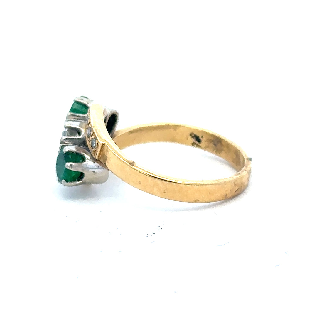 18ct yellow gold emerald and diamond ring, size N, featuring a central emerald with surrounding diamonds on a polished band.