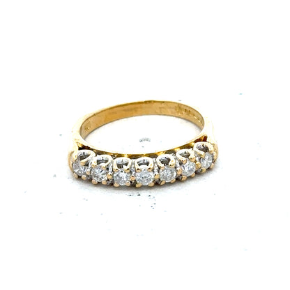 18ct yellow gold half eternity diamond ring with sparkling diamonds encircling the band, showcasing elegant jewelry design.