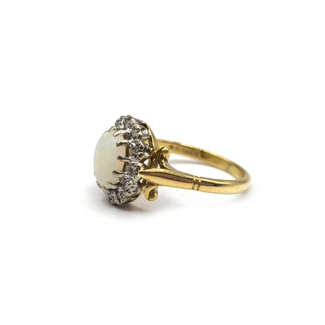18ct yellow gold ring featuring a vibrant opal and sparkling diamonds, elegant jewelry piece with intricate design.