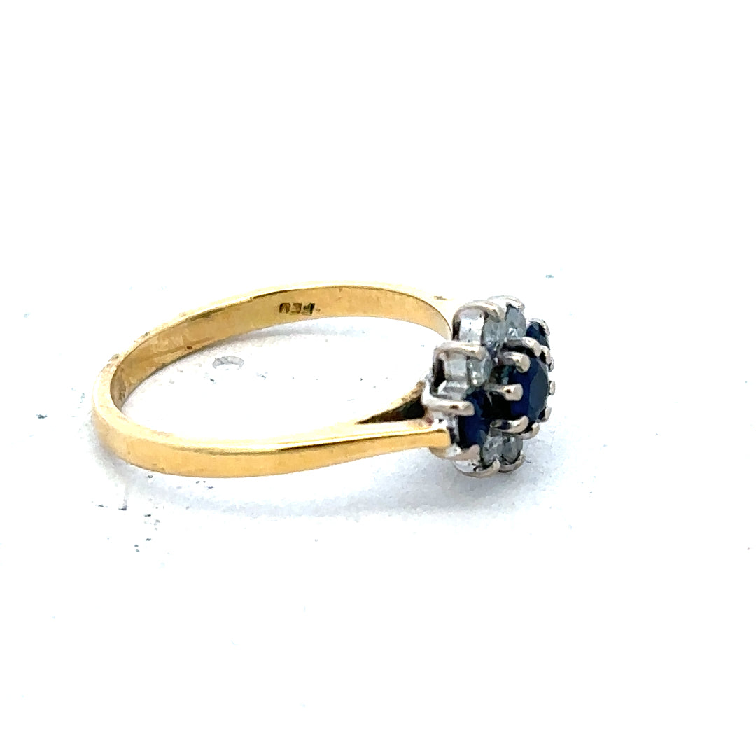 18ct yellow gold sapphire and diamond ring, size K, featuring a central sapphire with diamond accents, styled as a elegant jewelry piece.