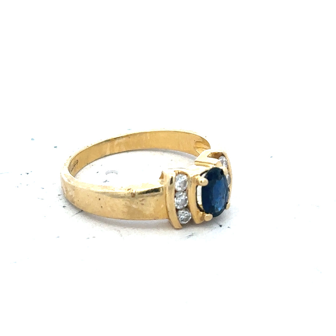 18ct yellow gold sapphire and diamond ring, size M, featuring a central sapphire with surrounding diamonds on a sleek band.