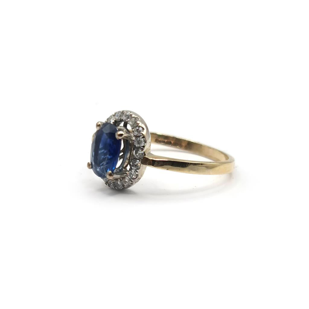 18ct yellow gold sapphire and diamond ring featuring a central blue sapphire and sparkling diamonds, elegant jewelry piece.