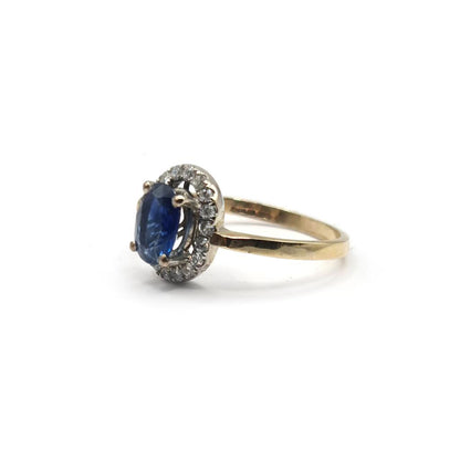 18ct yellow gold sapphire and diamond ring featuring a central blue sapphire and sparkling diamonds, elegant jewelry piece.