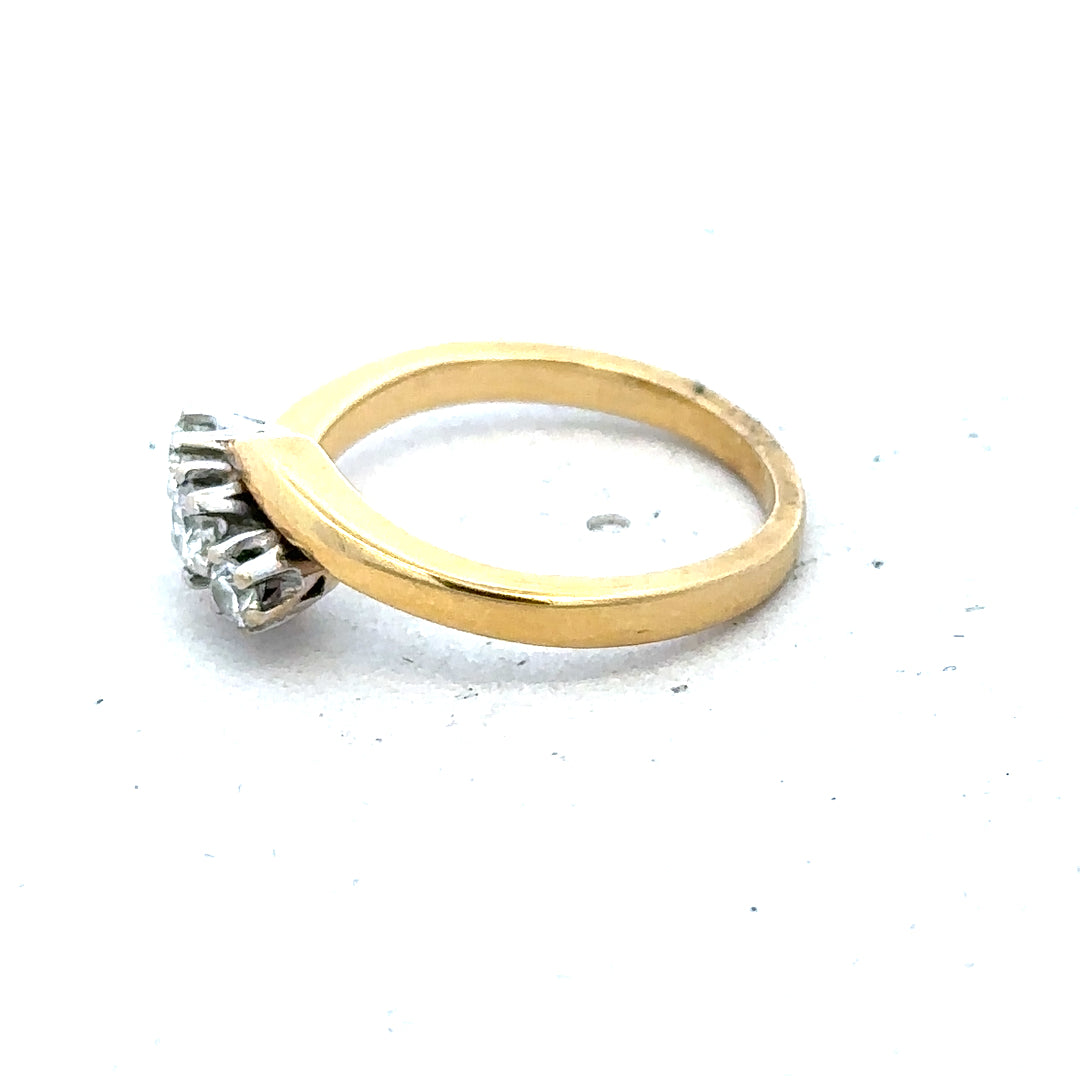 18ct yellow gold ring featuring three sparkling diamonds, elegant jewelry piece with a classic design.