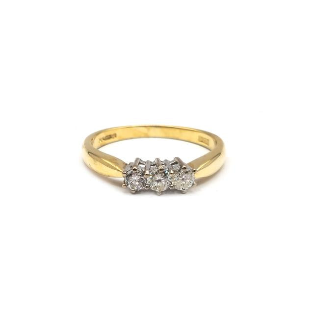 18ct yellow gold ring with three diamonds, showcasing elegant design and sparkling gemstones.