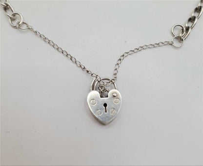 925 silver charm bracelet with intricate details, weighing 27.3g, featuring various charms and a polished finish.