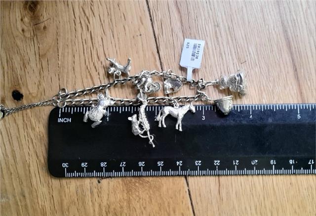 925 silver charm bracelet with intricate design, weighing 27.3g, showcasing detailed charms and craftsmanship.