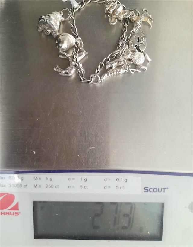 925 silver charm bracelet with intricate designs, weighing 27.3g, featuring detailed charms and a secure clasp.