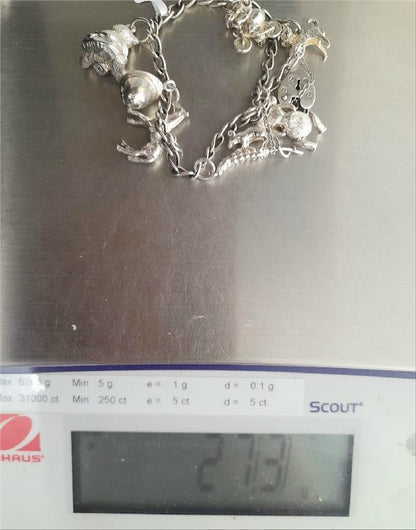 925 silver charm bracelet with intricate designs, weighing 27.3g, featuring detailed charms and a secure clasp.
