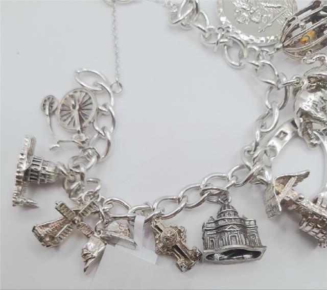 Silver charm bracelet made of 925 silver, 7 inches long, weighing 53.6g, featuring various decorative charms.
