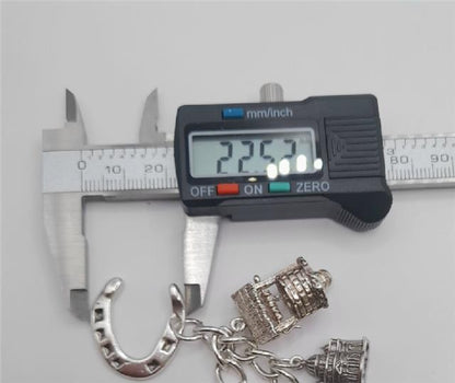 925 silver charm bracelet weighing 53.6g and measuring 7 inches, featuring intricate charms and a secure clasp.