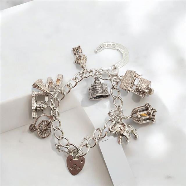 925 silver charm bracelet weighing 53.6g, 7-inch length, unbranded jewelry accessory with detailed silver charms.