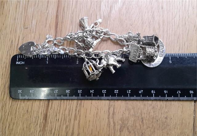 925 silver charm bracelet, unbranded, 7 inches long, weighing 53.6g, featuring decorative charms on a silver bracelet.