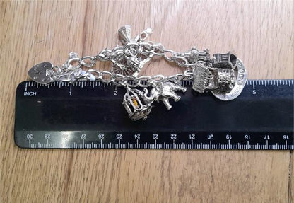 925 silver charm bracelet, unbranded, 7 inches long, weighing 53.6g, featuring decorative charms on a silver bracelet.