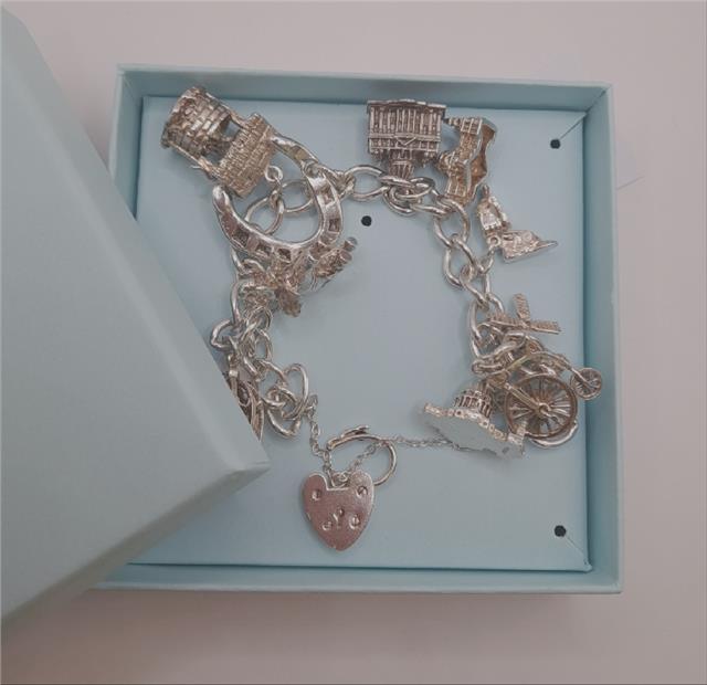 925 silver charm bracelet weighing 53.6g, 7 inches long, featuring detailed charms, unbranded jewelry accessory.