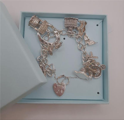 925 silver charm bracelet weighing 53.6g, 7 inches long, featuring detailed charms, unbranded jewelry accessory.