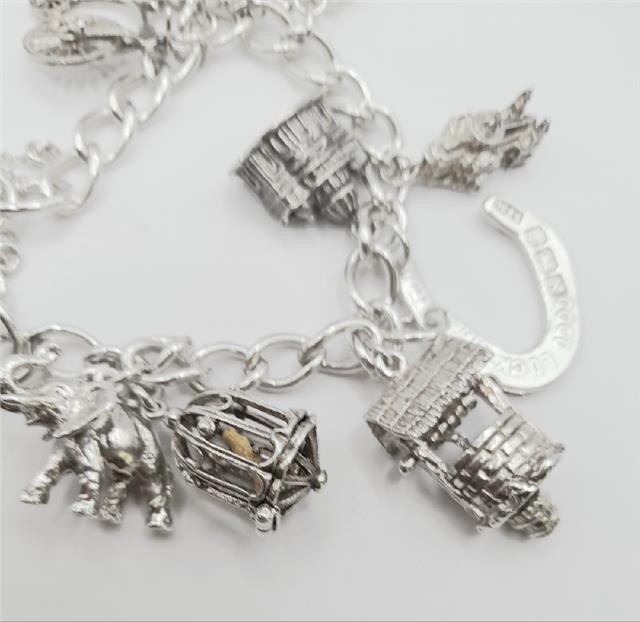 925 silver charm bracelet, unbranded, 7-inch length, 53.6g, detailed with various charms and intricate silver design.