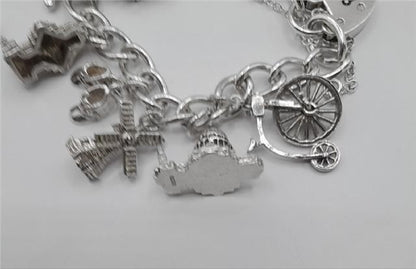 925 silver charm bracelet weighing 53.6g, 7-inch length, unbranded, featuring detailed silver charms and intricate design.