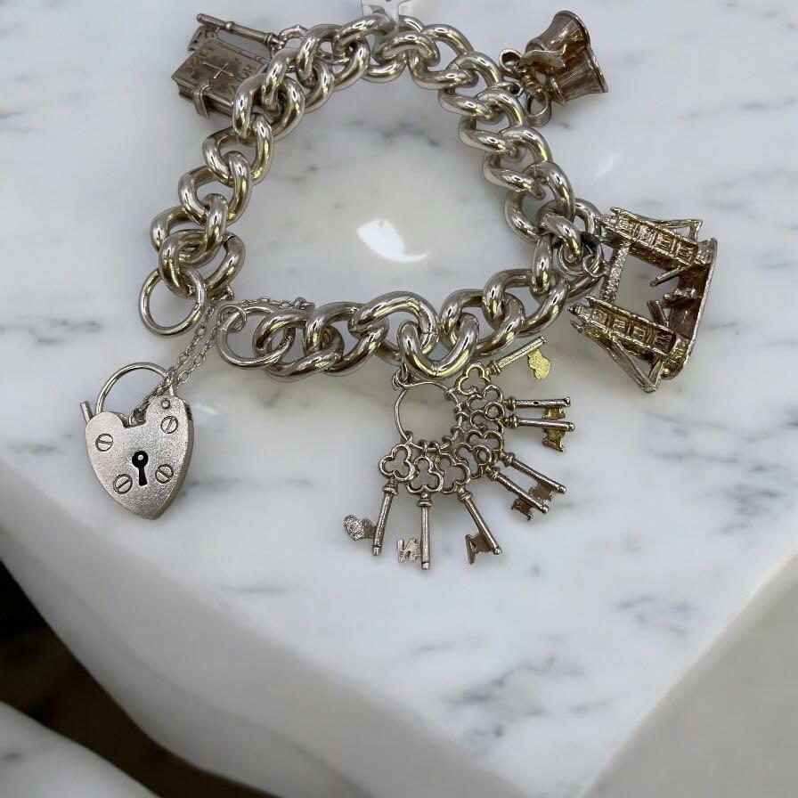 925 silver charm bracelet with intricate charms and delicate links, showcasing elegant craftsmanship and a polished finish.