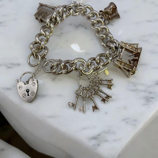 925 silver charm bracelet with intricate charms and delicate links, showcasing elegant craftsmanship and a polished finish.