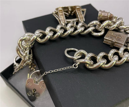 Silver charm bracelet with intricate designs, crafted from 925 silver, featuring multiple decorative charms and a secure clasp.