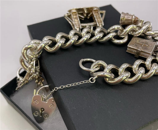 Silver charm bracelet with intricate designs, crafted from 925 silver, featuring multiple decorative charms and a secure clasp.