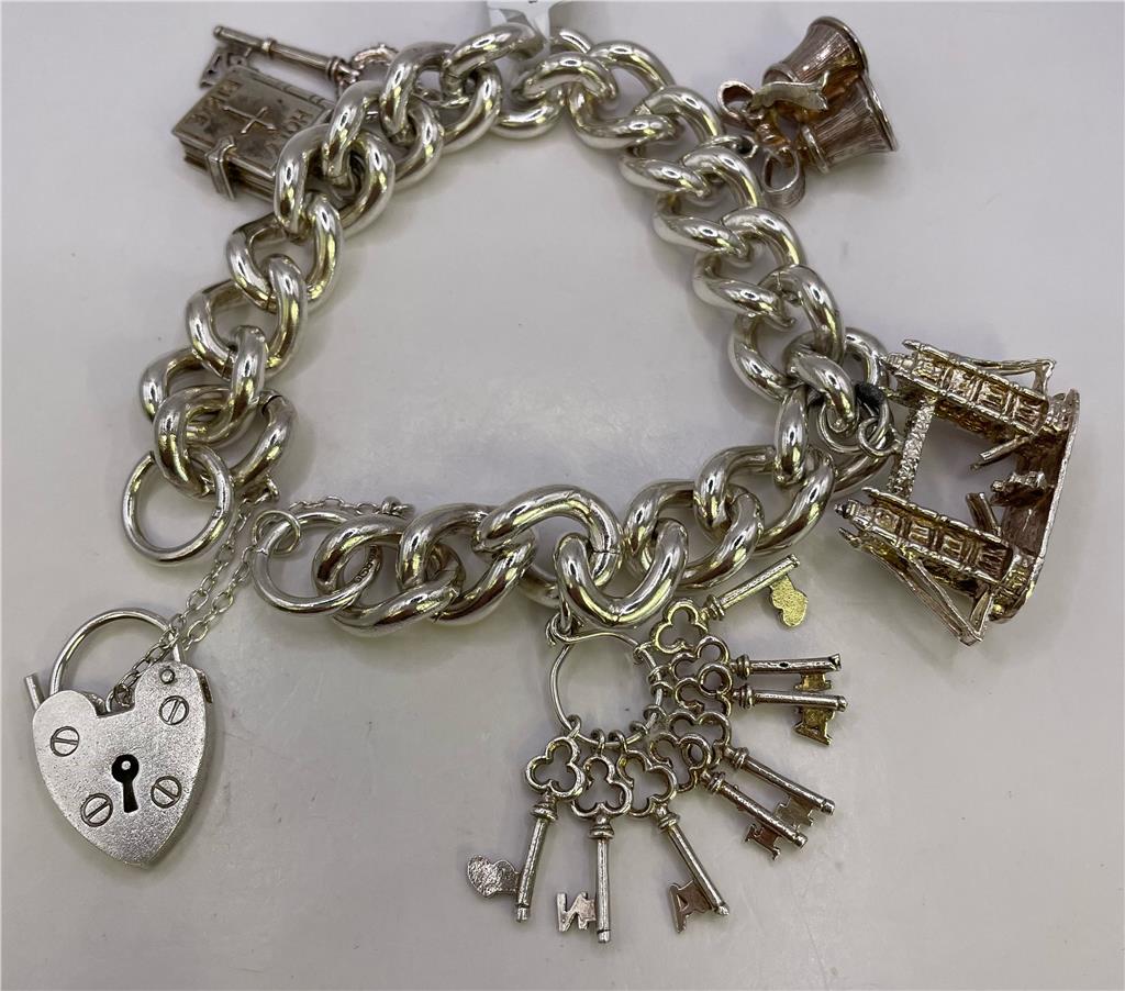 Silver charm bracelet featuring intricate designs, crafted from 925 sterling silver, with multiple decorative charms for a stylish look.