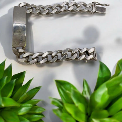 Sterling silver ID bracelet with engraved plate, unbranded, showcasing a sleek and polished design on a plain background.