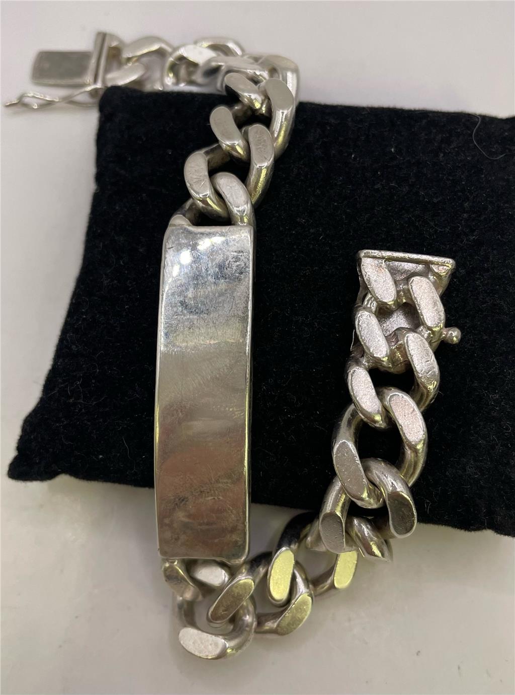 Sterling silver ID bracelet with smooth band and engraved plate, unbranded jewelry accessory for men or women.