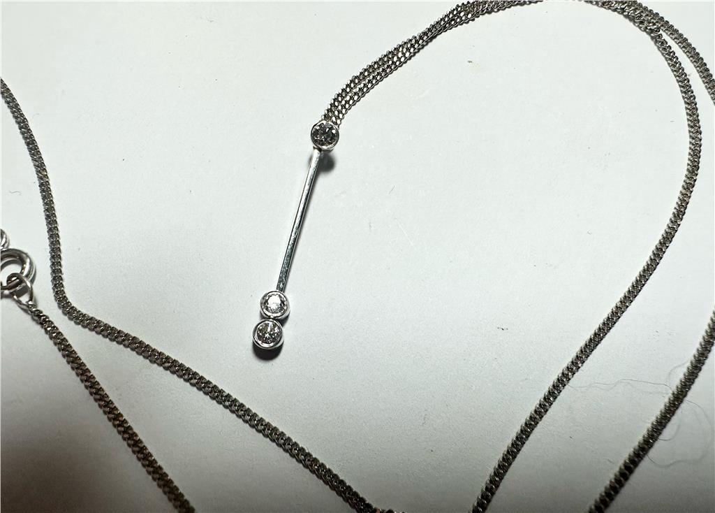 9ct white gold chain with an 18ct white gold diamond pendant, featuring sparkling diamonds and a delicate, elegant design.