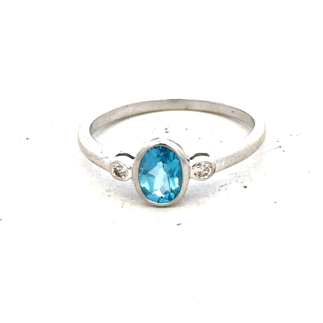 9ct white gold ring with a blue topaz and diamond accents, size Q, featuring a polished band and elegant design.