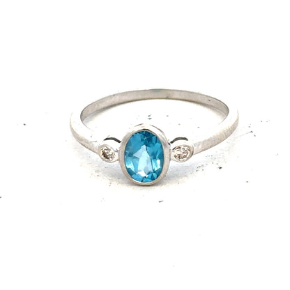 9ct white gold ring with a blue topaz and diamond accents, size Q, featuring a polished band and elegant design.