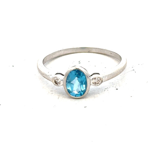 9ct white gold ring with a blue topaz and diamond accents, size Q, featuring a polished band and elegant design.