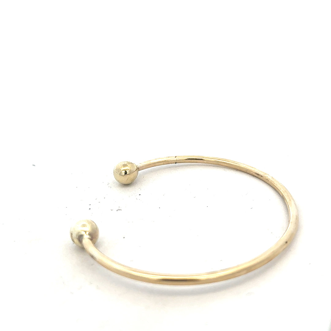 9ct yellow gold bracelet bangle weighing 12.7g, unbranded, with a smooth, polished finish.